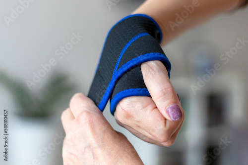 Fotografiet Women's hands wear a fixing bandage on the wrist