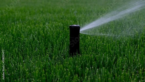 Automatic garden irrigation system watering lawn. Savings of water from sprinkler irrigation system with adjustable head. Automatic equipment for irrigation and maintenance of lawns, gardening.