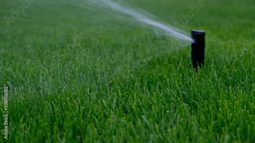 Automatic garden irrigation system watering lawn. Savings of water from sprinkler irrigation system with adjustable head. Automatic equipment for irrigation and maintenance of lawns, gardening.