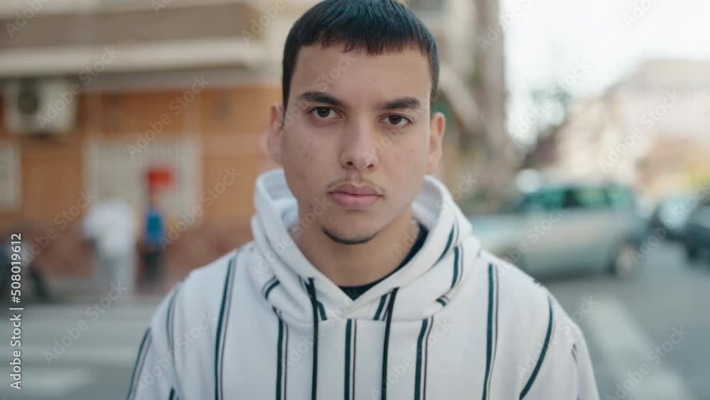 Young man with relaxed expression standing at street Young man with relaxed expression standing at street