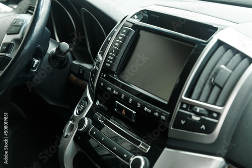 The interior of a modern car in close-up. Car interior - steering wheel, gear shift lever, multi steering wheel, car control display, dashboard. Black leather. A place to copy. Without a label. © Evgenii