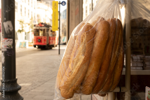 Canvas Print Stale bread in plastic bag on door on background of red retro nostalgic tram in Istiklal street in Istanbul