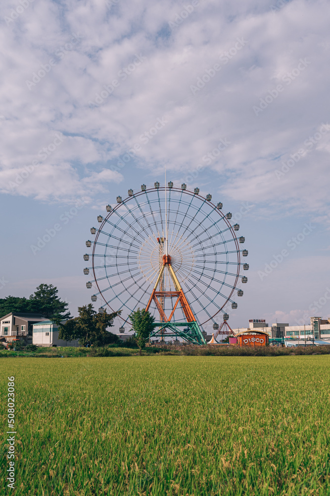 A ferris wheel standing tall on a clear autumn day