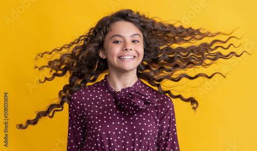 Photography kid smile with long brunette curly hair on yellow background