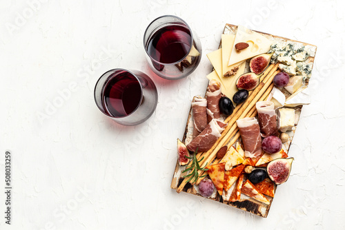 Cheese platter and wine. Assorted cheese, ham, fruit, bread sticks, nuts. banner, menu, recipe place for text, top view