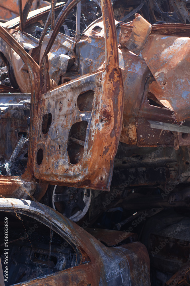 rusty burnt cars in Irpen, after being shot by Russian military and missile. Russia's invasion. war against Ukraine. Cemetery of destroyed cars of civilians who tried to evacuate from war zone rusty burnt cars in Irpen, after being shot by Russian military and missile. Russia's invasion. war against Ukraine. Cemetery of destroyed cars of civilians who tried to evacuate from war zone
