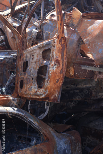 rusty burnt cars in Irpen, after being shot by Russian military and missile. Russia's invasion. war against Ukraine. Cemetery of destroyed cars of civilians who tried to evacuate from war zone