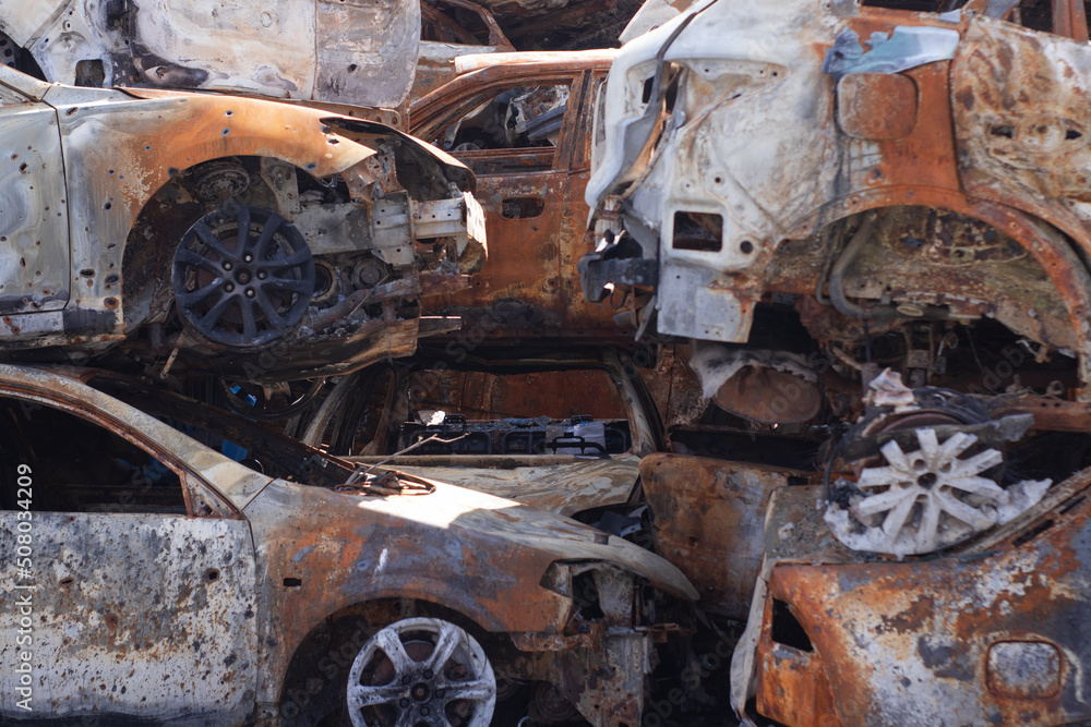 car graveyard. Burnt and blown up car. Cars damaged after shelling from russian invasion. War between Russia and Ukraine. Terror attack bomb shell. Disaster area irpin bucha