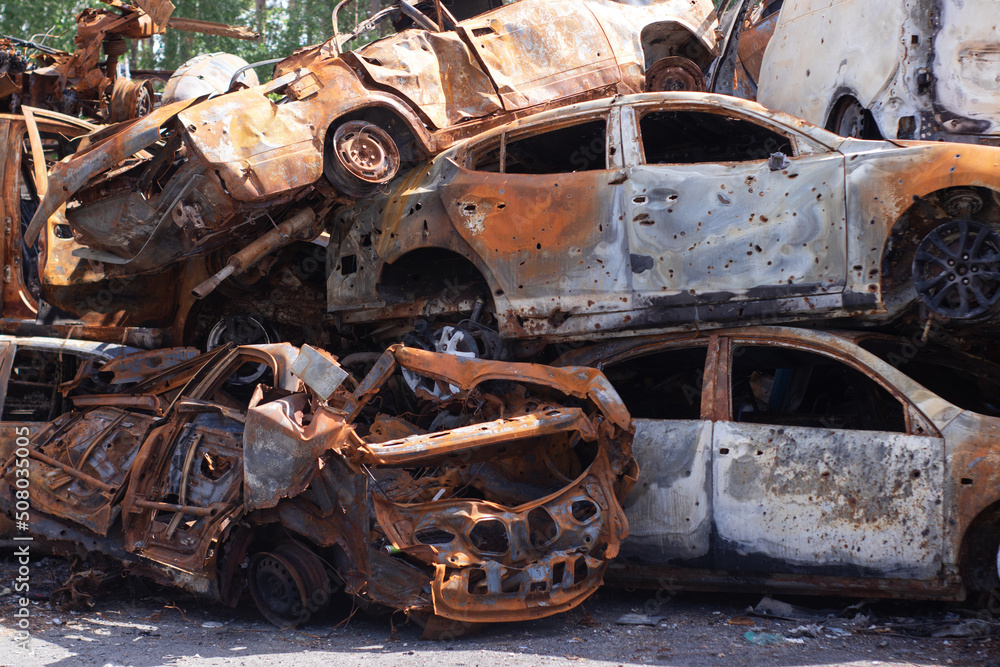 rusty burnt cars in Irpen, after being shot by Russian military and missile. Russia's invasion. war against Ukraine. Cemetery of destroyed cars of civilians who tried to evacuate from war zone