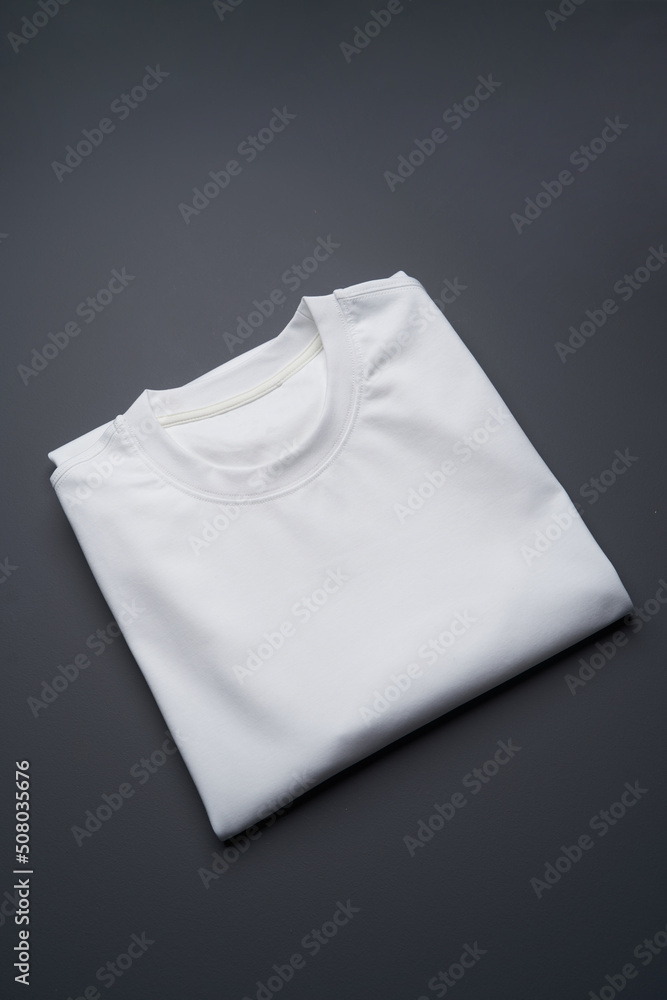 Folded t-shirt on a gray background, top view Folded t-shirt on a gray background, top view