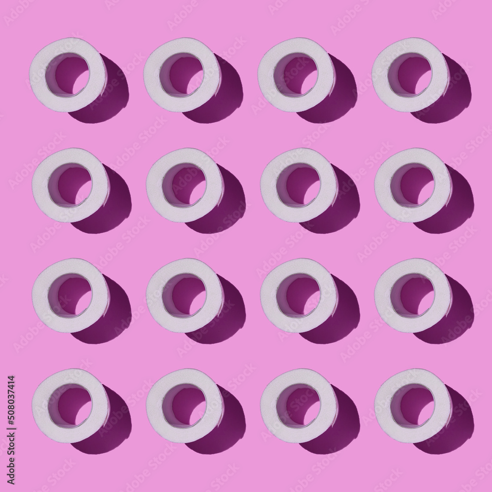 Fototapeta premium Pattern made of Toilet paper rolls isolated on pink background. New Corona virus infection background. Pandemic panic concept.