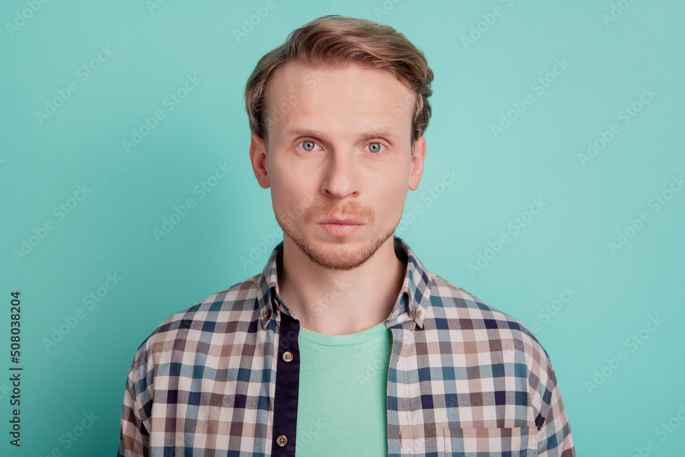 Photo of serious focused man look camera prepare barbershop visit wear checkered shirt on teal color background Photo of serious focused man look camera prepare barbershop visit wear checkered shirt on teal color background