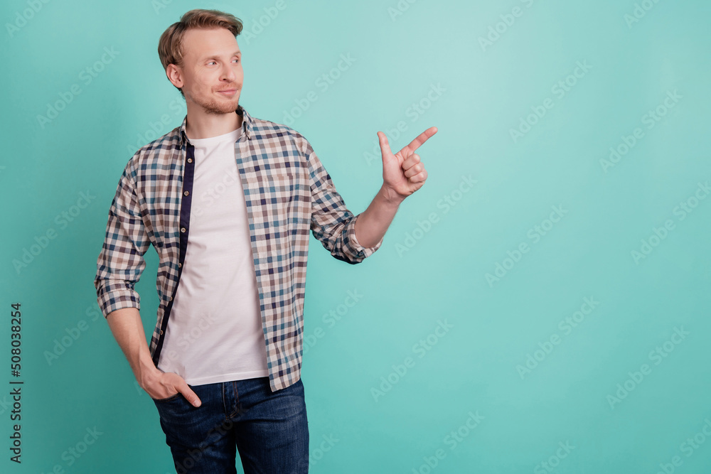 Photo of curious reliable man direct forefinger promo banner blank space wear plaid shirt on teal color background Photo of curious reliable man direct forefinger promo banner blank space wear plaid shirt on teal color background