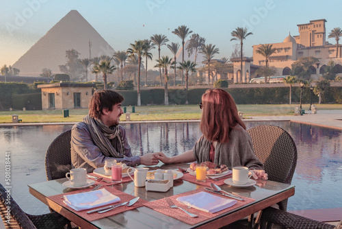 Couple enjoying breakfast with a view over the Pyramids of Giza in Caïro.