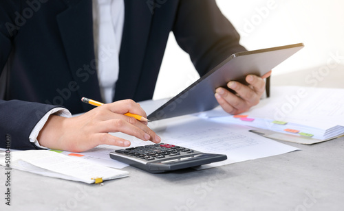 A woman filling out a Korean tax return (the text in the document is in Korean, and the basic form and tax form for general receipts)