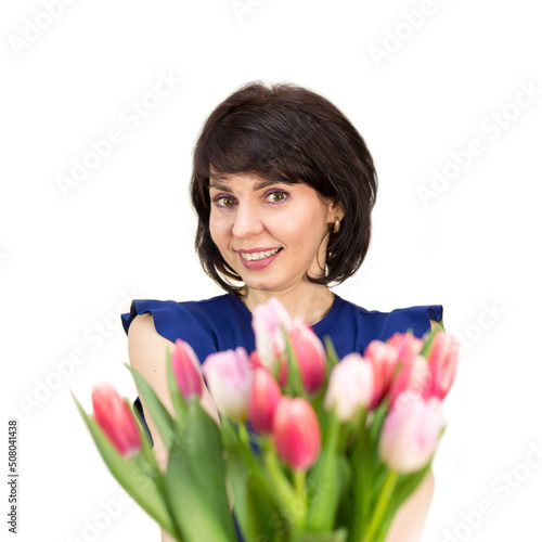 The seller of the flower shop offers a beautiful bouquet of spring flowers.