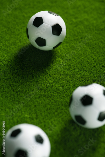 Several soccer balls on a green grass field. Start Qatar 2022. © dimasobko