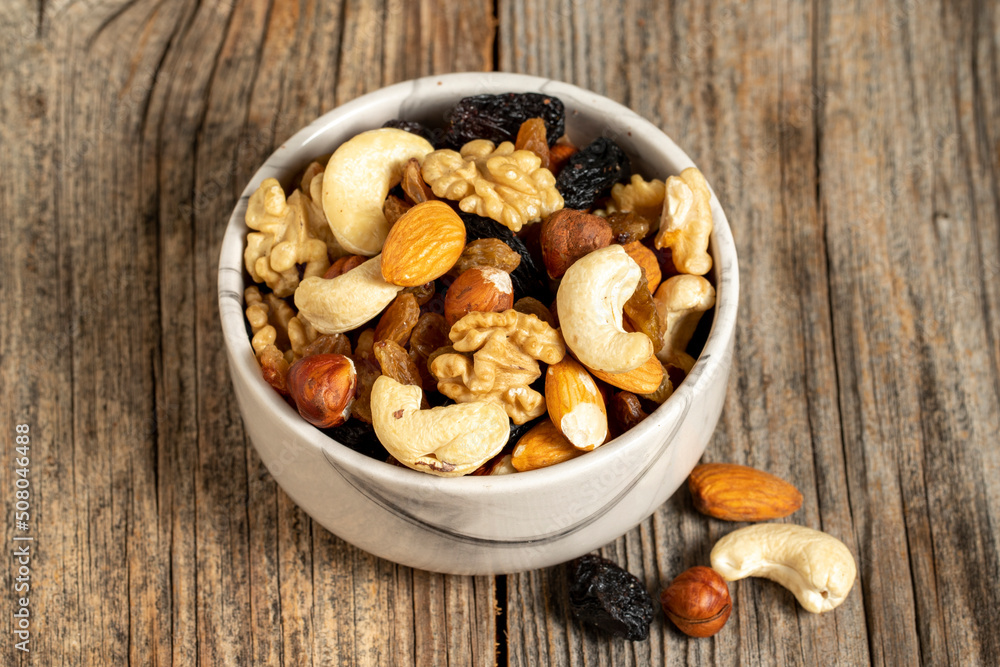 Mixed nuts on wooden background. Nuts, walnuts, raisins and cashews. close up Mixed nuts on wooden background. Nuts, walnuts, raisins and cashews. close up