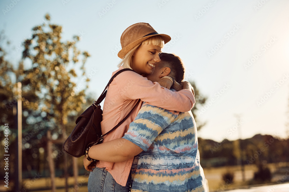 Young happy woman and her girlfriend embracing in park.