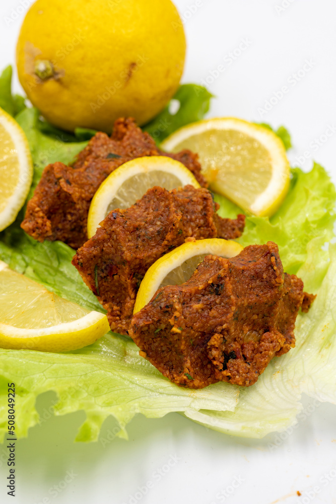 raw meatballs or cigkofte on a white background. Close-up. local name cig kofte