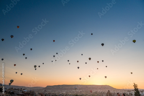 dozens of hot air balloons in the sky in Cappadocia