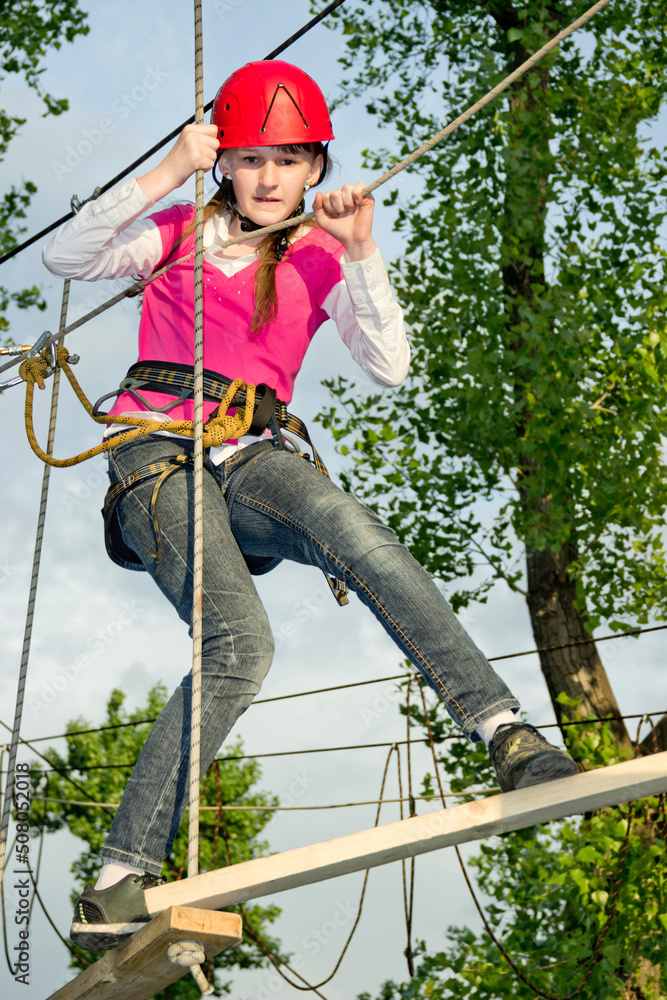 a teenage girl goes on hinged trail in extreme rope park