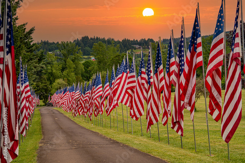 A display of United States flags at sunrise on Memorial Day along a road in a cemetary near Dallas Oregon photo