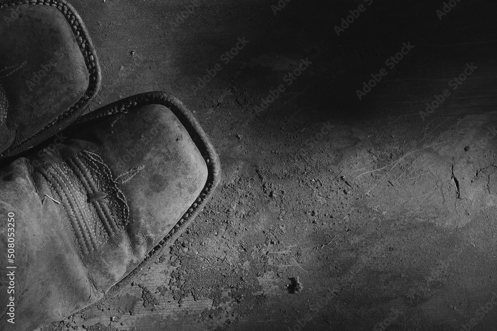 Old western cowboy boots from top view closeup in grunge dark black and white. - obrazy, fototapety, plakaty 