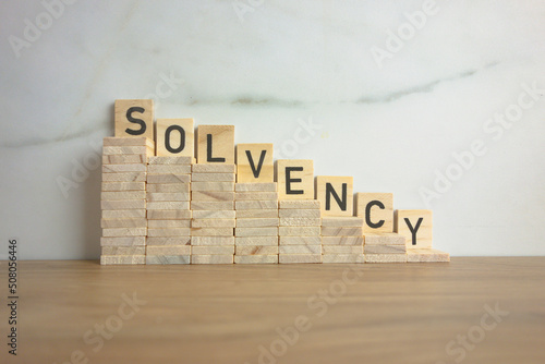 Wooden stairs down with word solvency. Creditworthiness, banking conditions concept photo