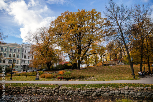 Riga, Latvia, 19 October 2021: Beautiful Bastejkalna Central Park with canals near the Latvian National Opera at autumn sunny day, bridge over water