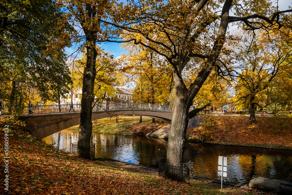 Riga, Latvia, 19 October 2021: Beautiful Bastejkalna Central Park with canals near the Latvian National Opera at autumn sunny day, bridge over water