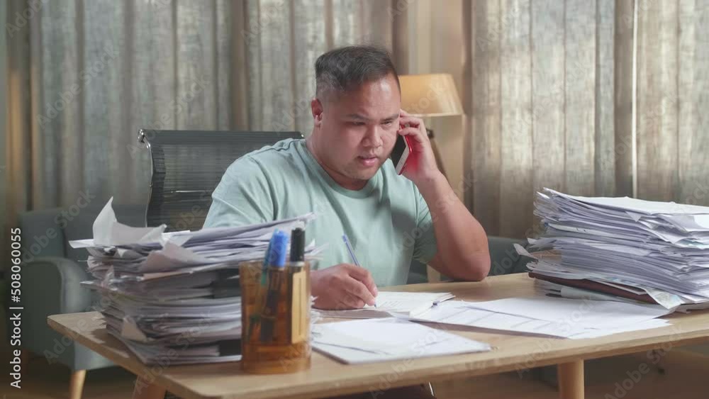 Fat Asian Man Talking On Phone And Taking Note While Working Hard With Documents At Office
Fat Asian Man Talking On Phone And Taking Note While Working Hard With Documents At Office
