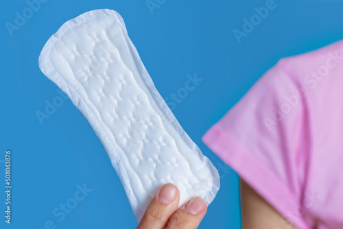 Girl holding in hand hygiene pad on blue background