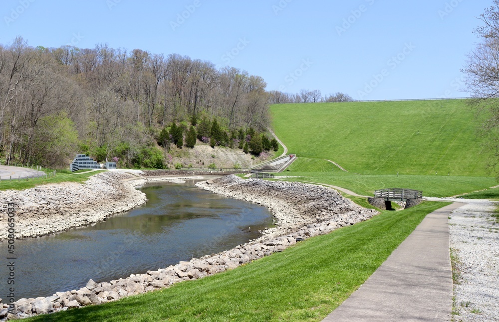 The flowing creek in the park on a sunny spring day. The flowing creek in the park on a sunny spring day.