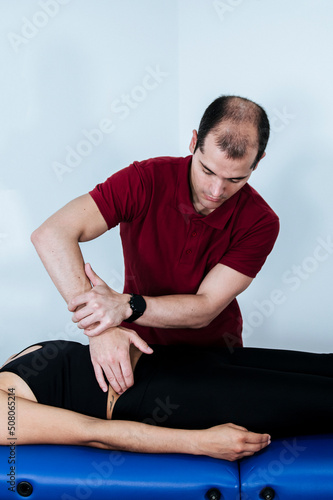 Boy therapist applying therapeutic acupressure on a young athletic woman