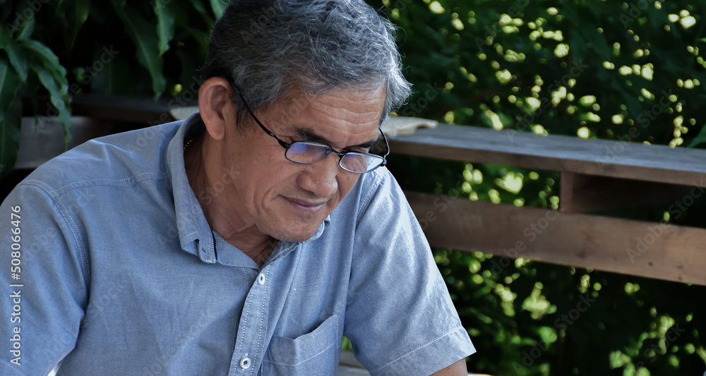 Portrait of senior elderly asian man who is relaxing at home with his free time activity.