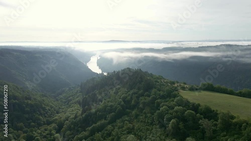 The steep and lush mountainsides of the moselle wine region on a misty spring morning. Wide angle aerial orbit photo