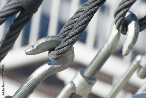 Metal turnbuckles and sling steel in construction site, close up. Fastening of cables with steel rod.