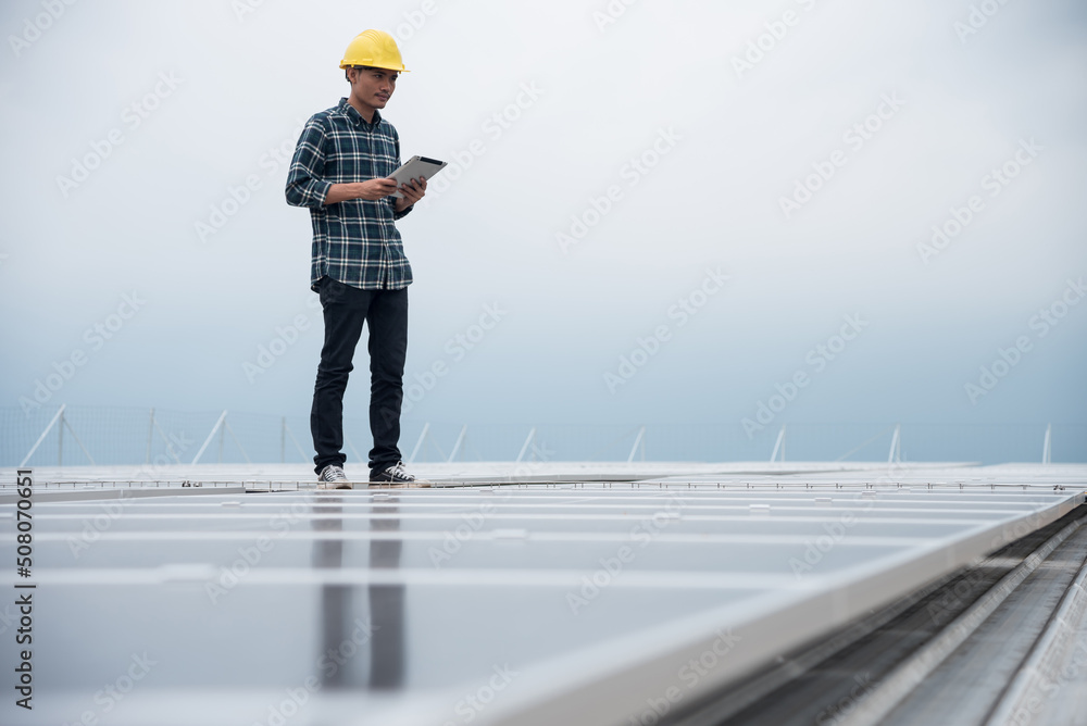 Technician works at a solar power station, Technology solar cell, Engineer check installation solar cell on the roof of factory. Technician inspection and repair solar cell on the roof of factory.