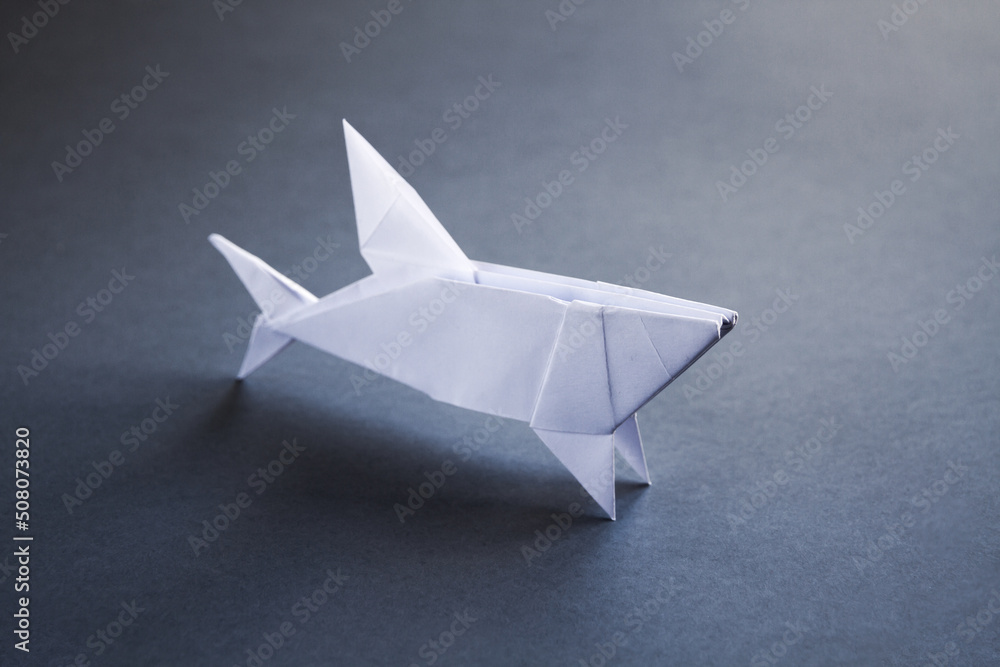 White paper shark origami isolated on a grey background - obrazy, fototapety, plakaty 