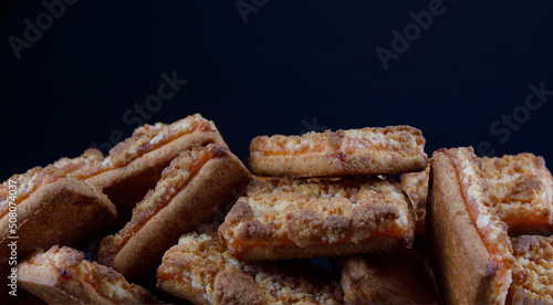 Background of beautiful cookies with orange filling . Square orange cookies .
