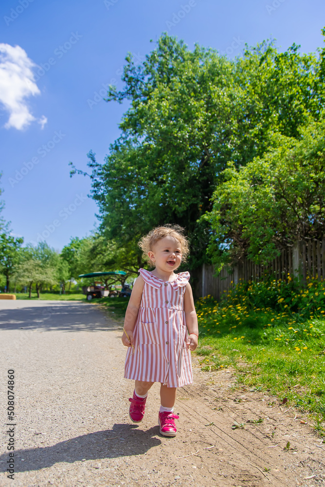 Child girl in the summer in the park. Selective focus. Child girl in the summer in the park. Selective focus.
