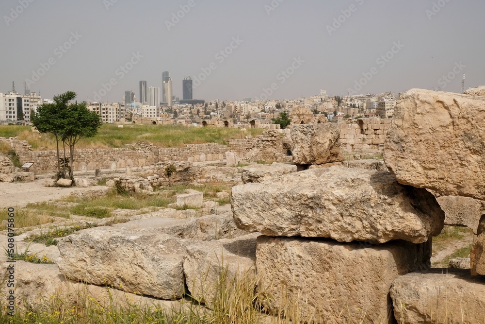 Ruins of Citadel Jebel Al Qala'a in Amman, Jordan. Panorama of Amman city with modern buildings in background.