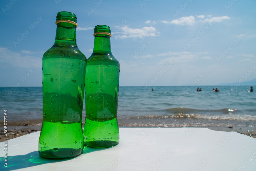 Water bottle on a white table, on the beach. Hydration and drinking regime Water bottle on a white table, on the beach. Hydration and drinking regime