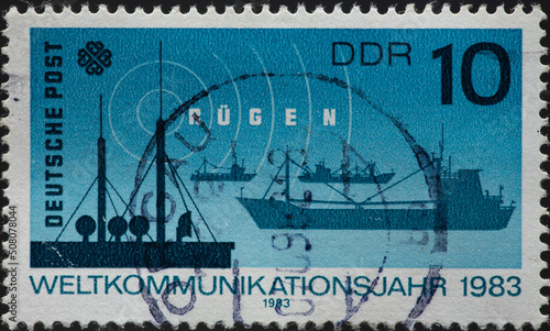 GERMANY, DDR - CIRCA 1983: a postage stamp from GERMANY, DDR, showing the coast radio station Rügen Radio , ships .World Communication Year . Circa 1983