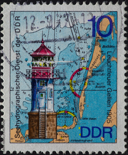 GERMANY, DDR - CIRCA 1975 a postage stamp from GERMANY, DDR, showing the historic lighthouse in Gellen (built 1905). In the background maps of the Baltic Sea. Circa 1975