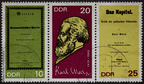 a postage stamp from GERMANY, DDR, showing a portrait of the philosopher and political economist Karl Marx. With Manifestos of the Communist Party and Das Kapital. Circa 1968