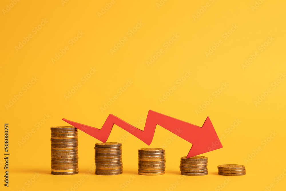 Stacks of coins and a red arrow graphic down arrow. Inflation. Stagflation Stacks of coins and a red arrow graphic down arrow. Inflation. Stagflation