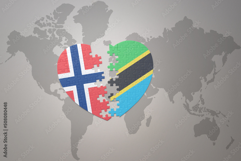 Obraz premium puzzle heart with the national flag of norway and tanzania on a world map background. Concept.