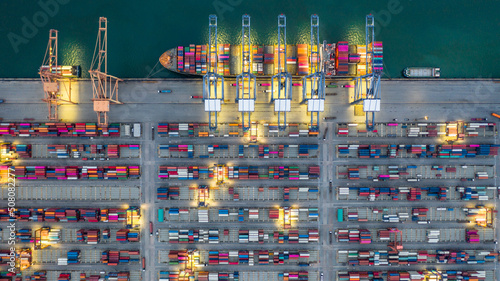 Aerial view container ship working at night terminal dock seaport, Global business company import export logistic transportation international container cargo freight shipping cargo vessel worldwide. © Kalyakan